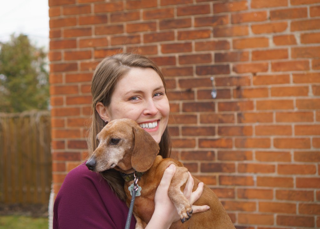 Amanda smiling and holding her dog